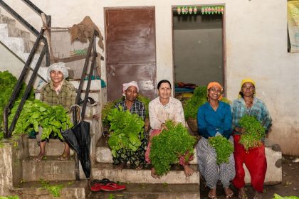 Grupo de mulheres agricultoras segura hortaliças frescas em uma área rural