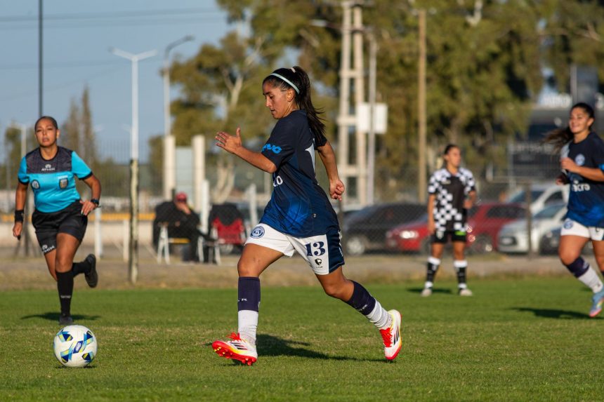 Jogadora de futebol em ação durante uma partida ao ar livre.